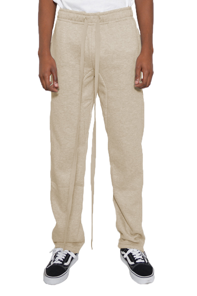 Beige sweatpants worn by a person on a white background
